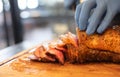 Closed up of chefÃ¢â¬â¢s hand slicing grilled medium rare beef steak on wooden board Barbecue Royalty Free Stock Photo